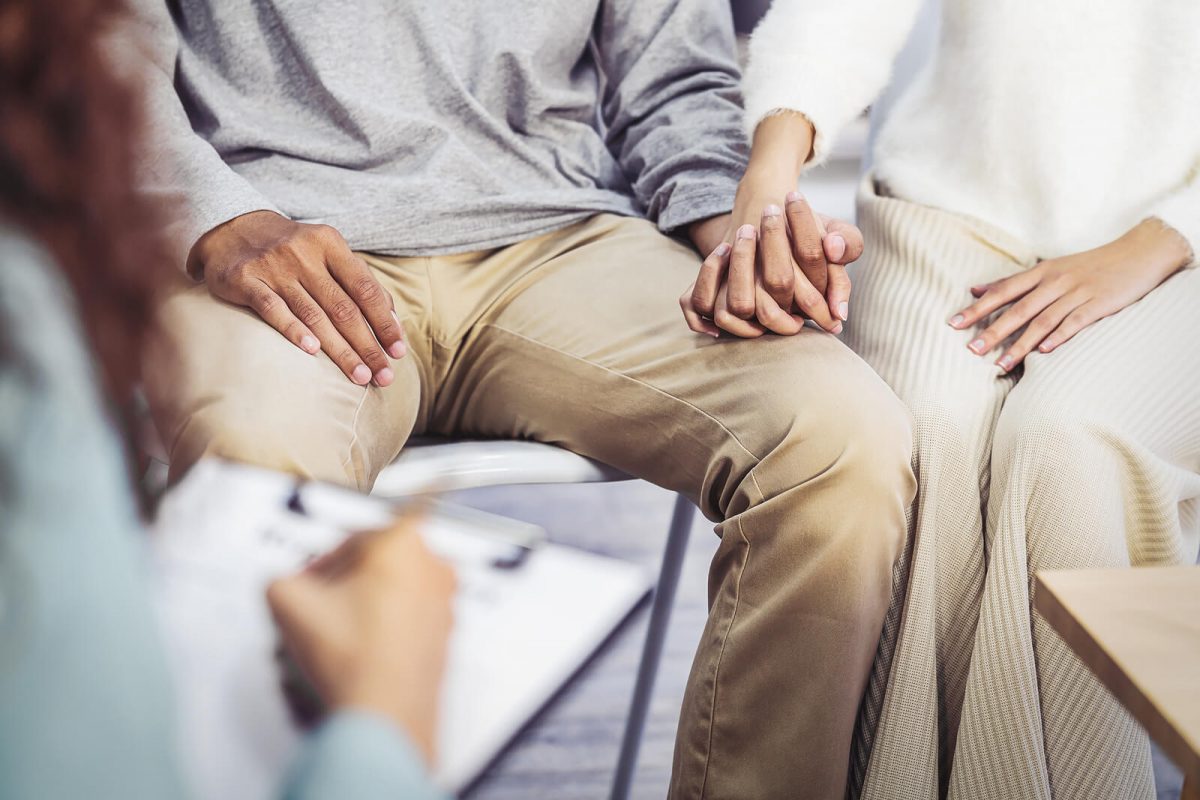A close-up of a couple holding hands as a person with a clipboard makes notes. This could represent how couples therapy in Scottsdale, AZ can support your relationship. Learn more about counseling in Scottsdale, AZ by contacting a couples therapist in Scottsdale, AZ today.